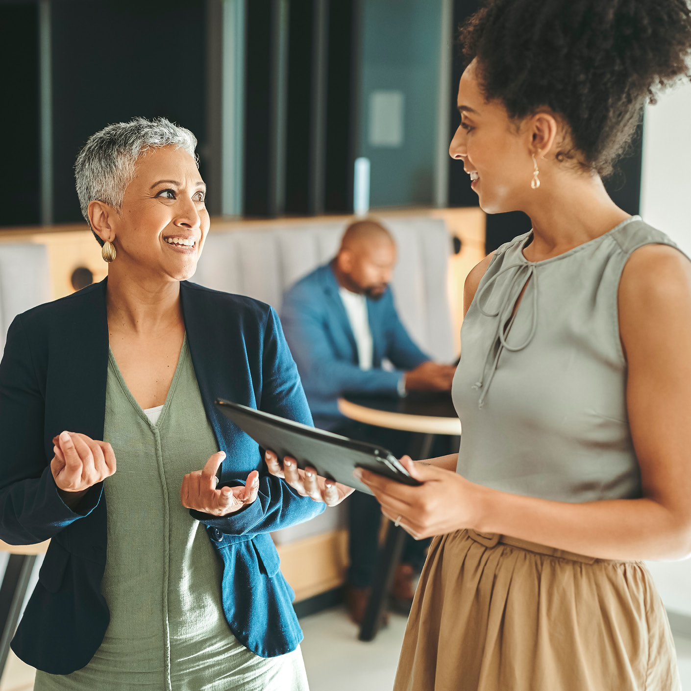 Two smartly dressed employees chat in their office