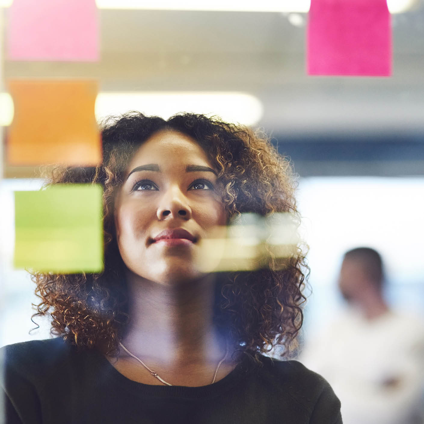 An employee looks at a board covered in colourful notes